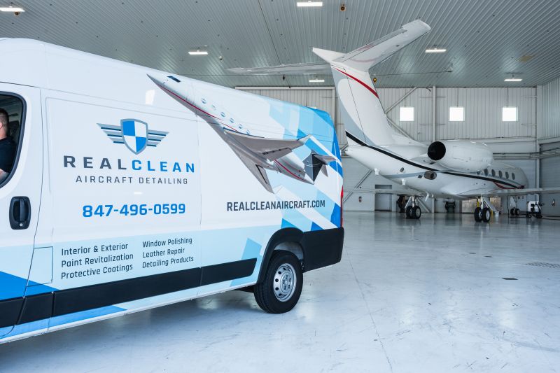 RealClean aircraft detailing van beside a private jet in a hangar