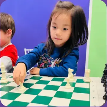 A child playing chess, pictured with Christine’s review