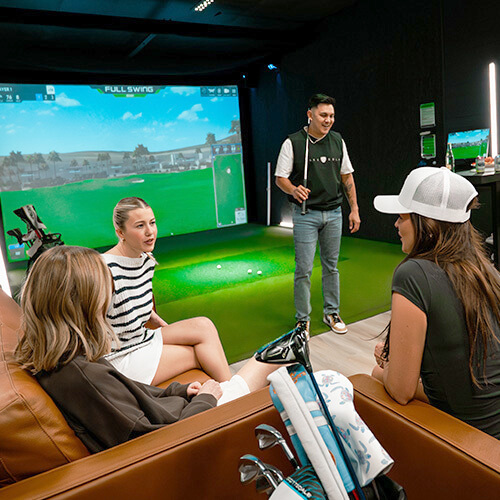 Friends enjoying an indoor golf simulator at Back Nine