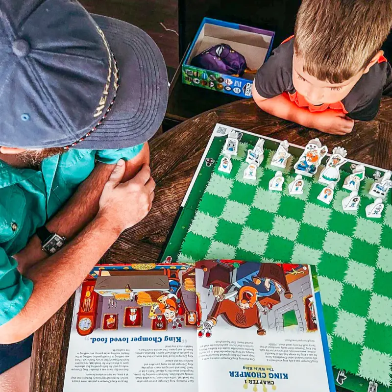 Children explore a colorful story-led chess board and illustrated character pieces.