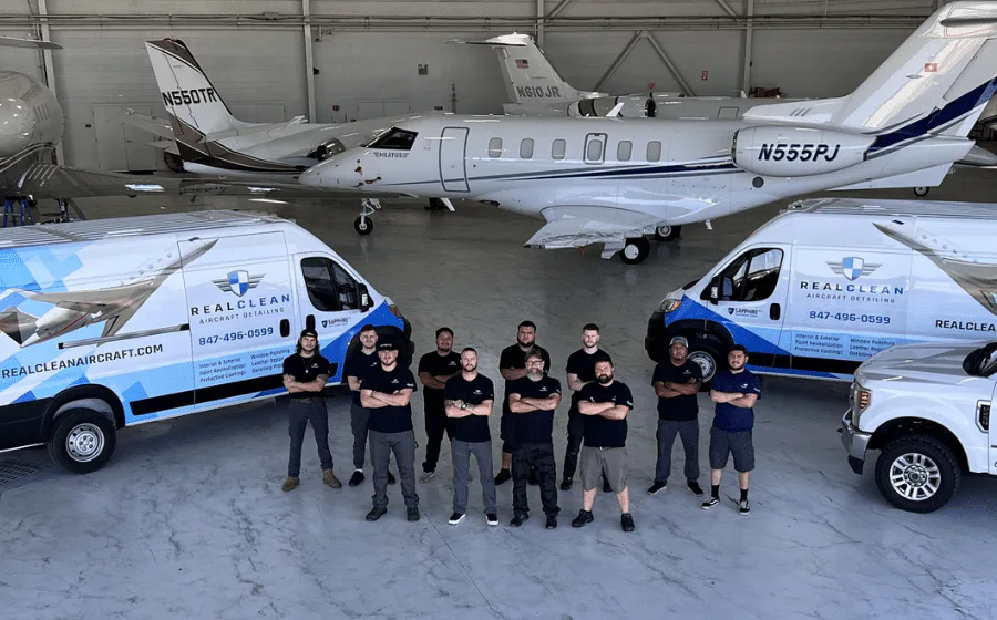 RealClean aircraft detailing team with service vans and business jets in a hangar